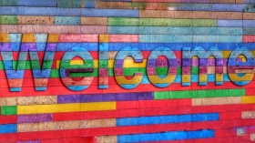 Colorful welcome on brick wall